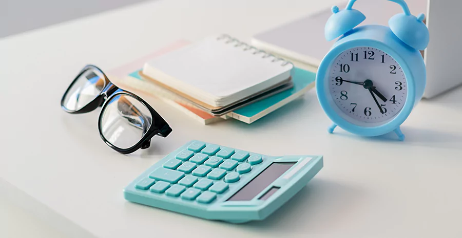 mesa com óculos, relógio e caderno, representando intervalo interjornada