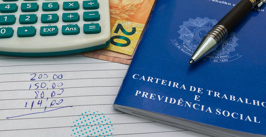 imagem de uma carteira de trabalho ao lado de uma calculadora e notas de dinheiro