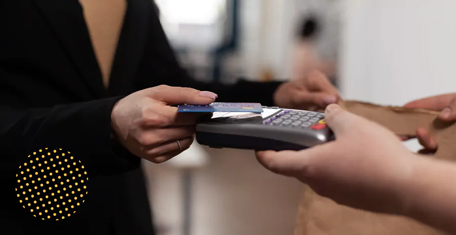 imagem de uma pessoa usando cartão para pagamento em uma máquina, representando auxílio alimentação