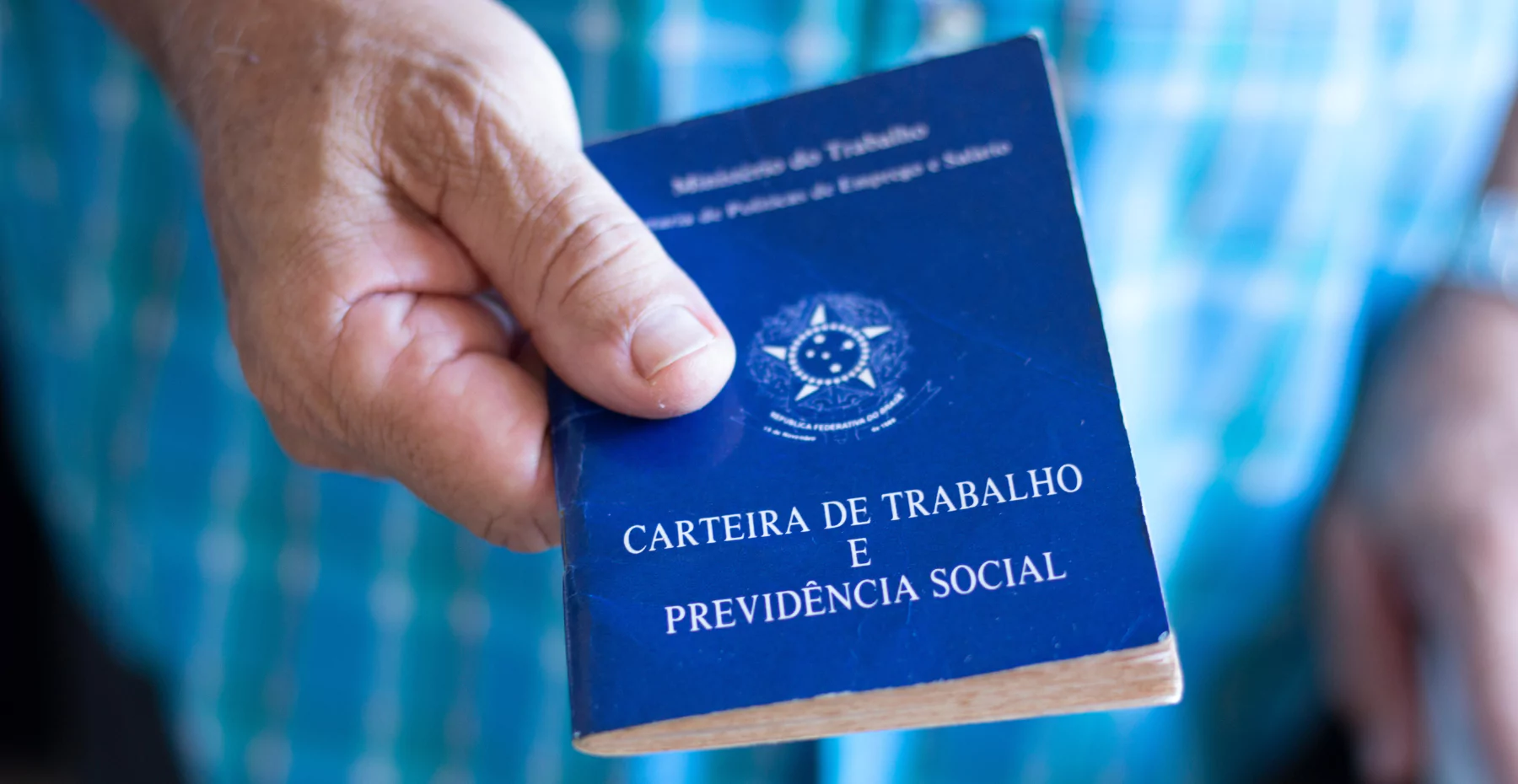 homem segurndo uma carteira de trabalho